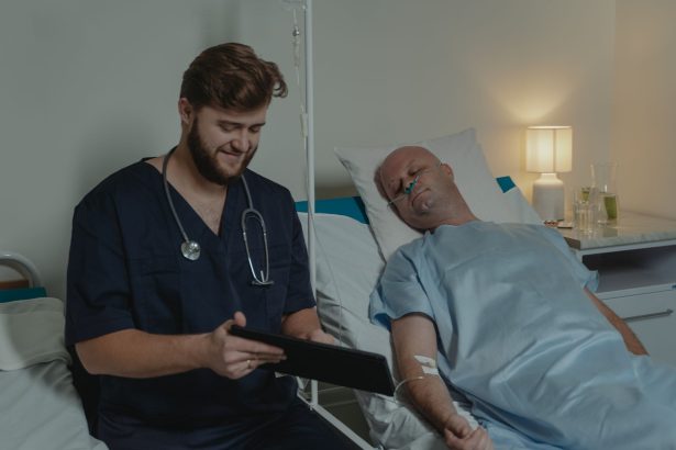 Profissional de saúde consulta um tablet enquanto acompanha paciente hospitalizado em um leito.