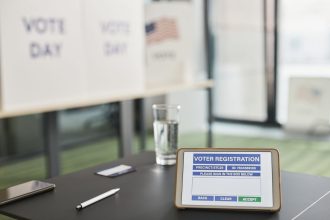 Tablet com tela de cadastro digital de eleitores em uma estação de votação interna