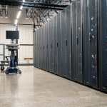 Racks metálicos com servidores, equipamentos de rede e cabos em um data center moderno