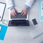 Profissional de saúde trabalhando em um computador em um consultório médico