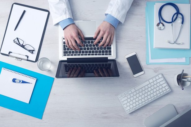 Profissional de saúde trabalhando em um computador em um consultório médico